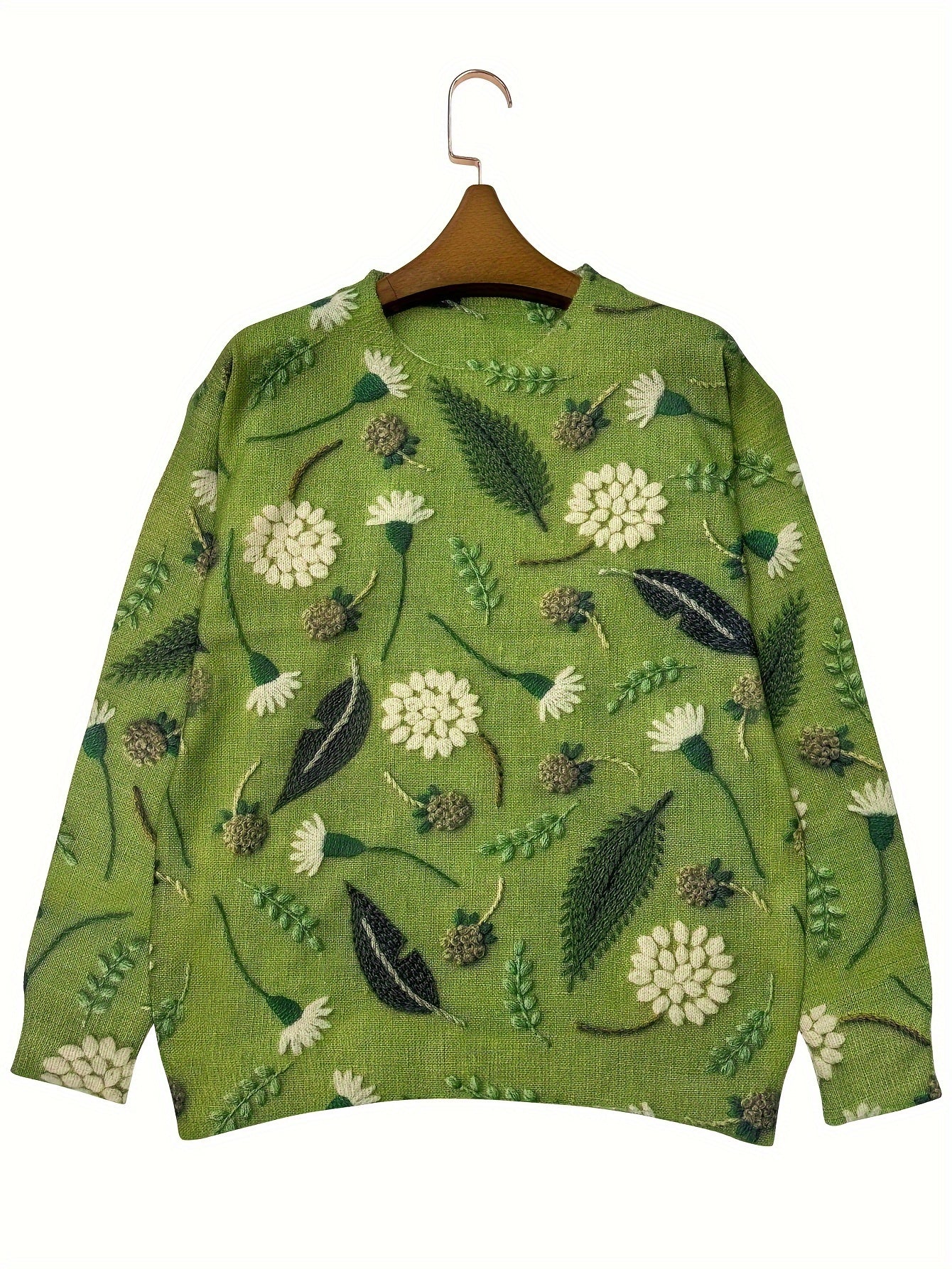 Green sweater with floral pattern on a hanger against a white background