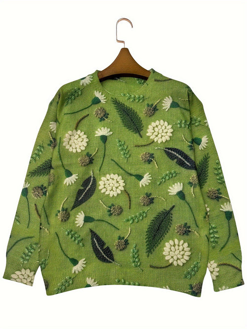 Green sweater with floral pattern on a hanger against a white background