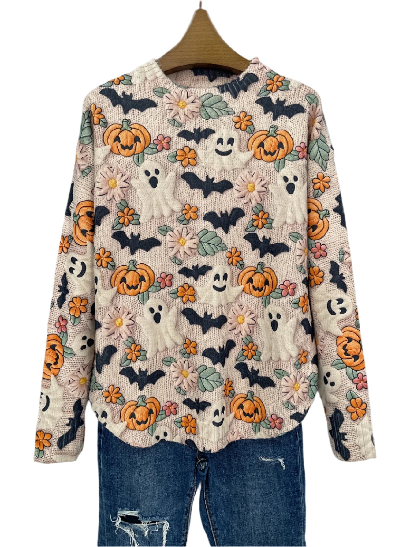 Halloween-themed sweater with pumpkins, ghosts, and bats on a hanger against a dark background.