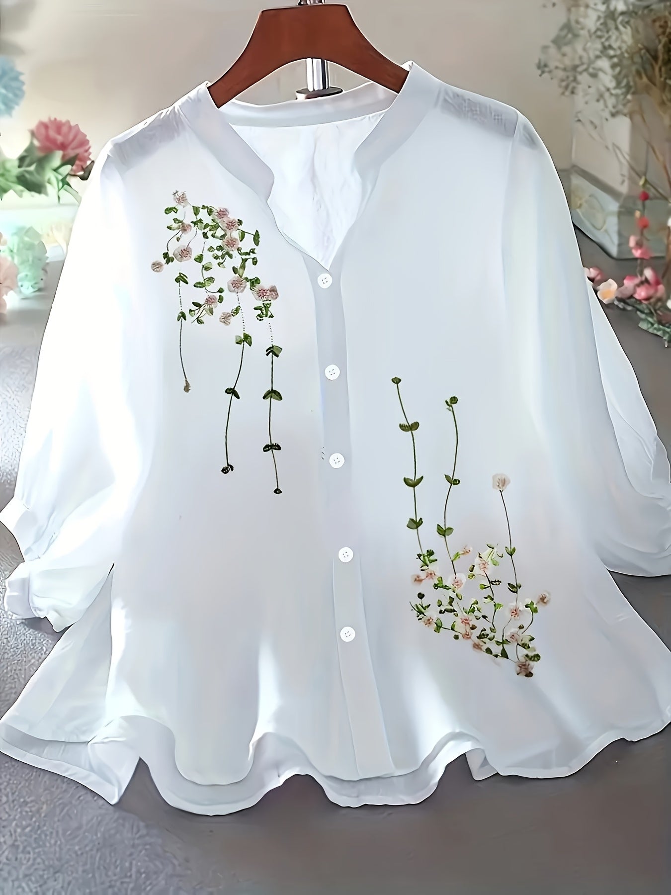 White blouse with floral embroidery on a hanger