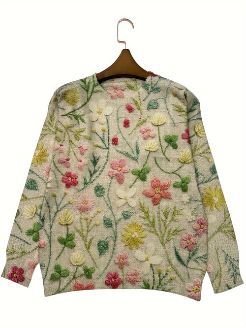 Floral embroidered sweater on a hanger against a white background