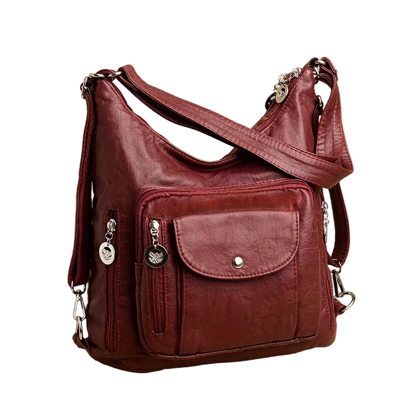 Brown leather handbag with multiple pockets and straps on a beige background