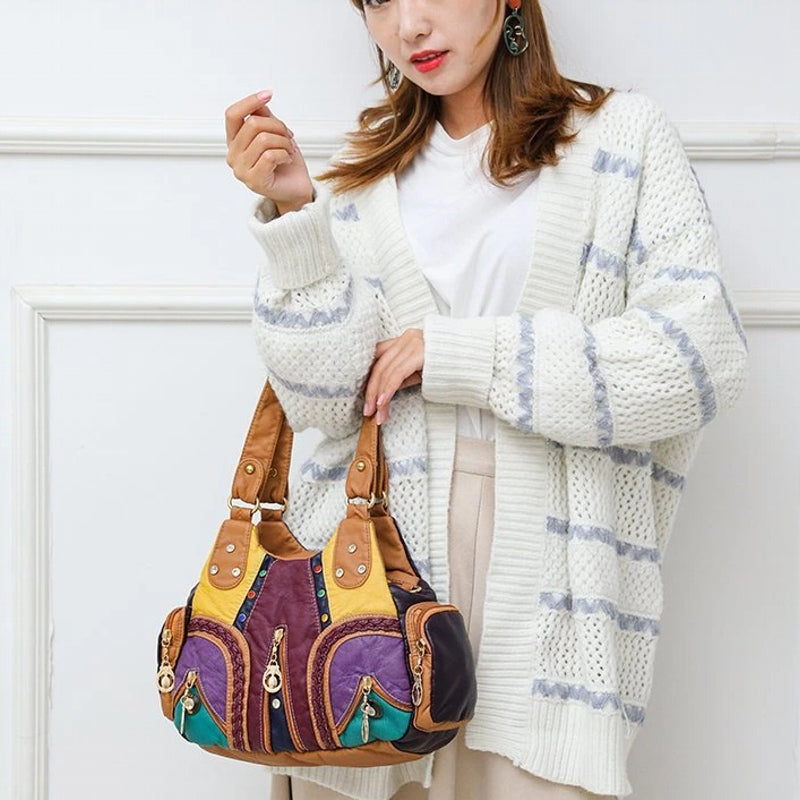 Woman holding a colorful patchwork handbag against a white background