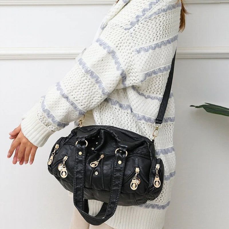 Person wearing a white and gray striped sweater with a black handbag.